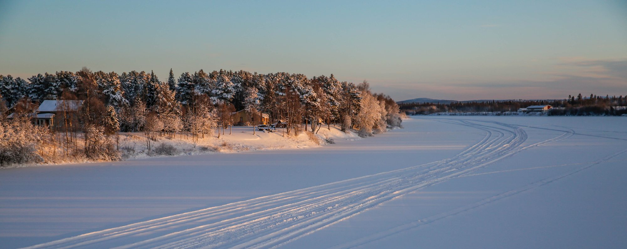 Frozen Ivalojoki river and snowy forest in Ivalo.
