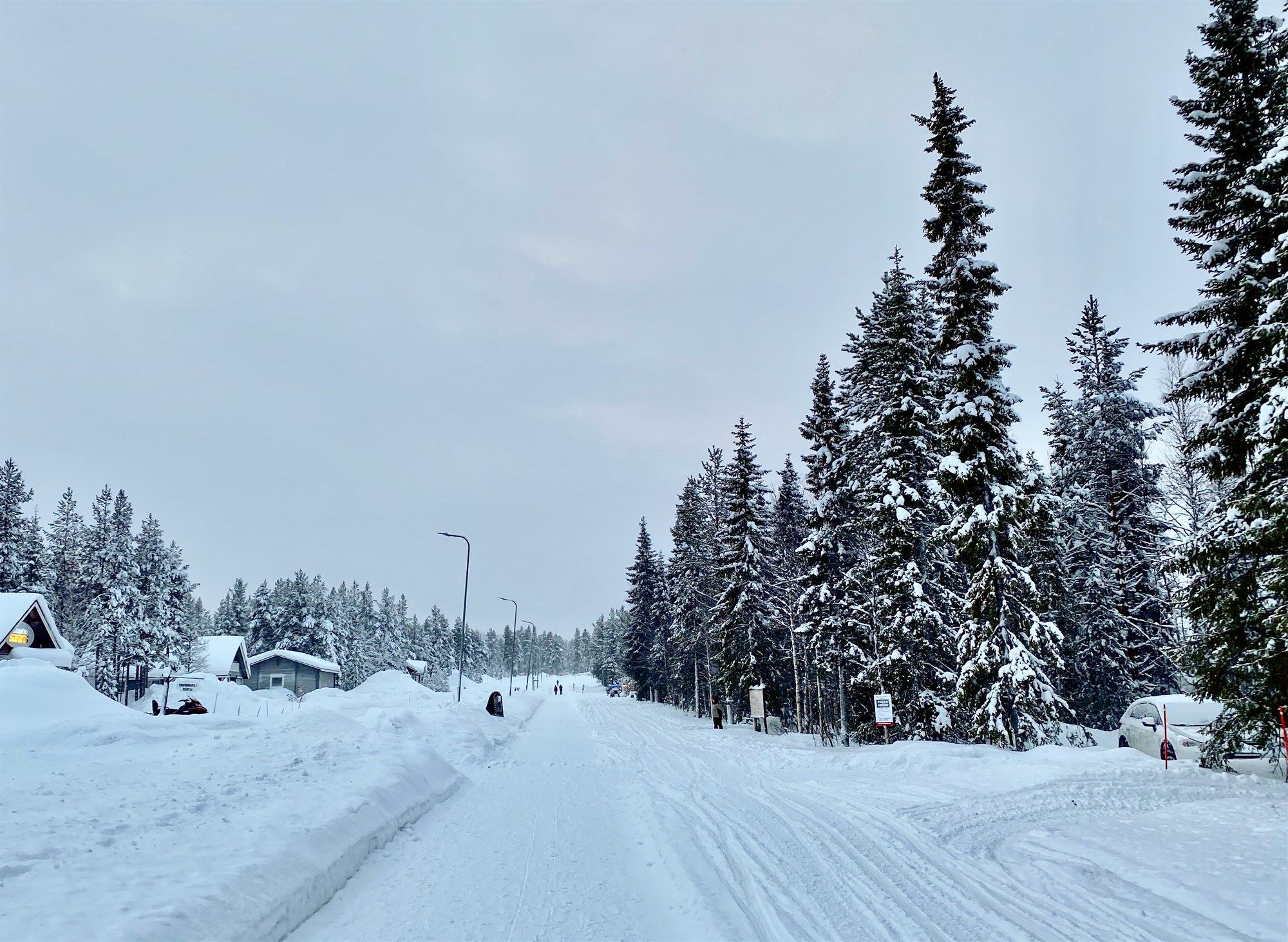 A snow-covered road through Äkäslompolo village in winter.