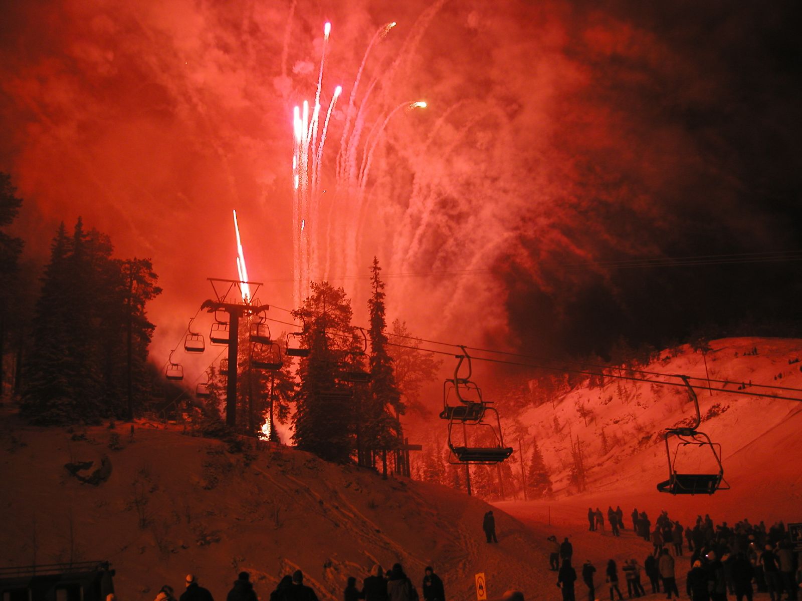 New Year fireworks glowing above a ski slope and chairlifts in Ruka, Finland.