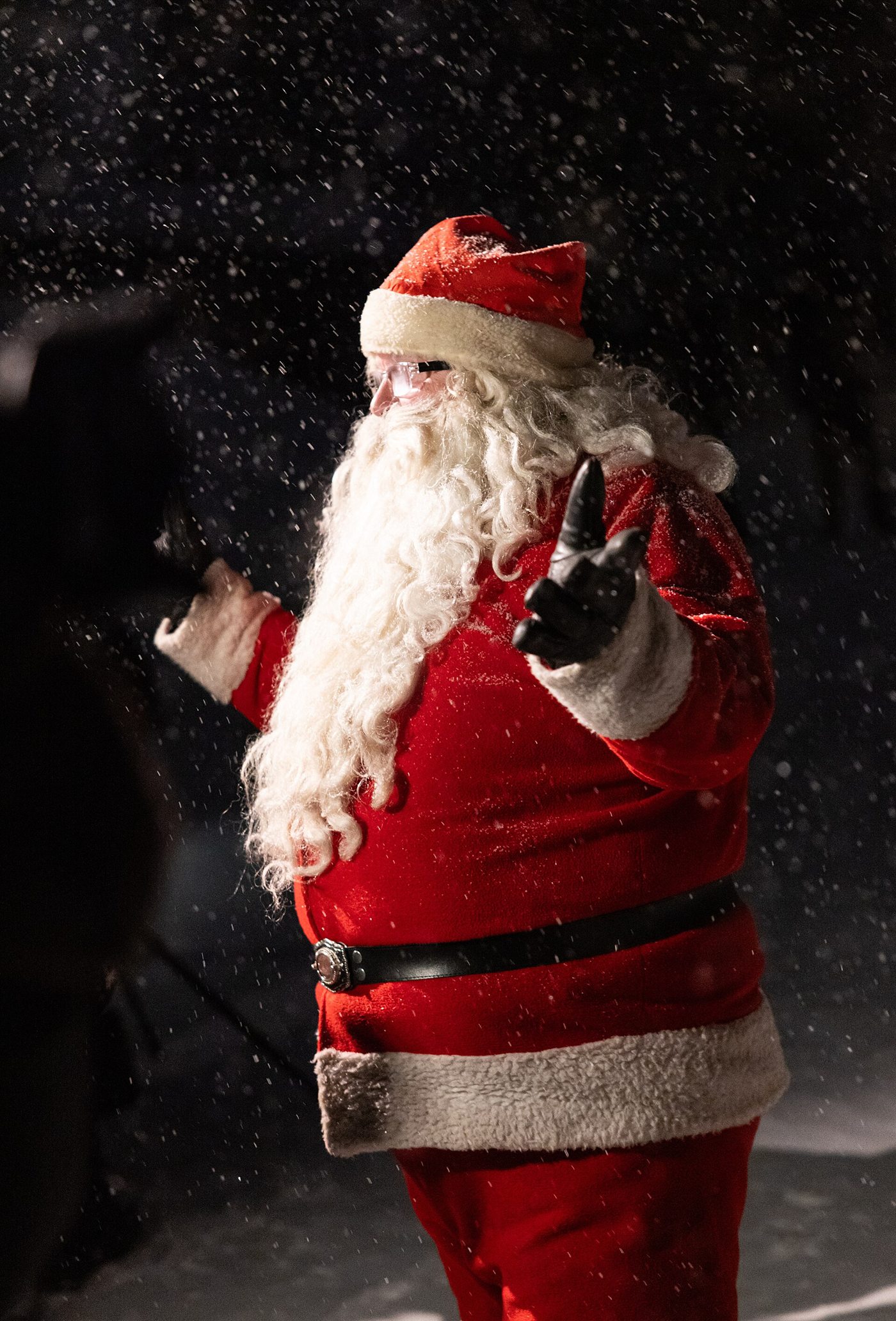 Santa Claus standing outdoors in falling snow in Saariselkä.