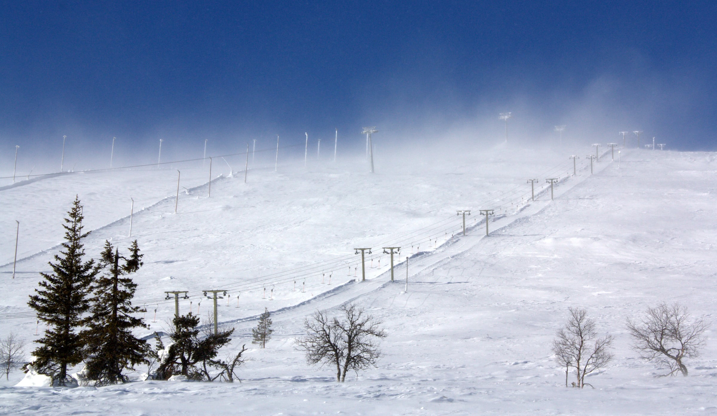 Broad snow-covered ski slopes and lifts across Ylläs fell.